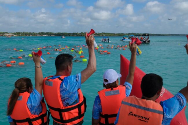 Mara Lezama da el banderazo de salida del XX Maratón de Aguas Abiertas en Bacalar, acompañada por autoridades y cientos de nadadores.