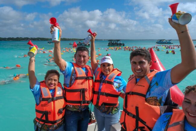Mara Lezama da el banderazo de salida del XX Maratón de Aguas Abiertas en Bacalar, acompañada por autoridades y cientos de nadadores.