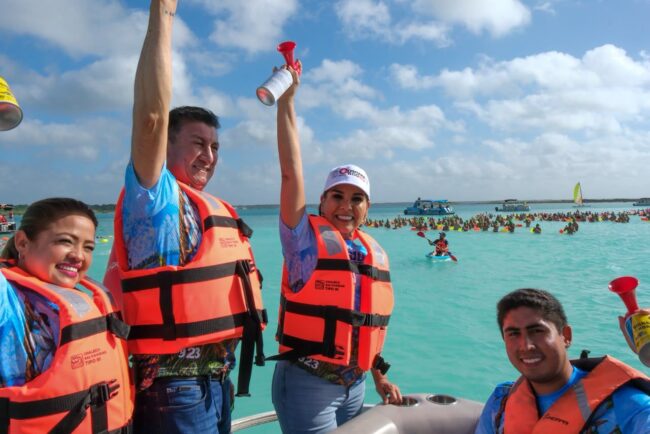 Mara Lezama da el banderazo de salida del XX Maratón de Aguas Abiertas en Bacalar, acompañada por autoridades y cientos de nadadores.